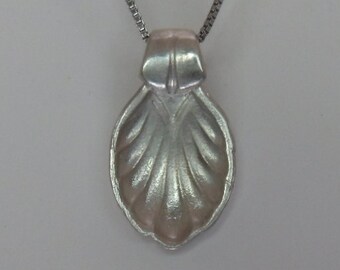 Sterling flatware shell pendant.