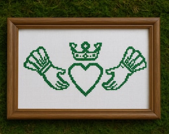 Peut inclure: Une broderie encadrée représentant le symbole de Claddagh, un emblème irlandais traditionnel. Le motif vert comprend un cœur, une couronne et des mains, sur fond blanc. Le cadre en bois ajoute une touche classique à ce symbole du patrimoine irlandais.