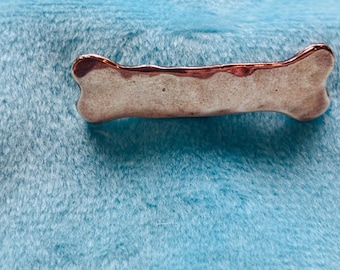 Gehämmerter Knochen aus 925er Silber mit einer Anstecknadel zurück.