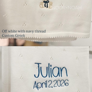 May include: Off-white and white baby blankets with custom embroidery. One blanket features the name "&Alpha;&nu;&delta;&rho;έ&alpha;&sigmaf;" in navy thread with a teddy bear design. The other blanket displays the name "Julian" and the date "April 2, 2026" in royal blue thread.