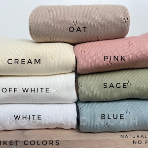 May include: A stack of rolled knit blankets in various colors, including oat, cream, pink, sage, and blue. Each blanket is labeled with its color name. The image also includes the text "Blanket Colors" and "Natural Light No Filter."