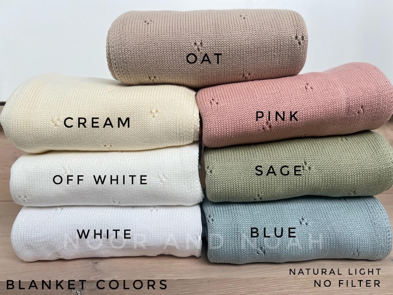 May include: A stack of rolled knit blankets in various colors, including oat, cream, pink, sage, and blue. Each blanket is labeled with its color name. The image also includes the text "Blanket Colors" and "Natural Light No Filter."