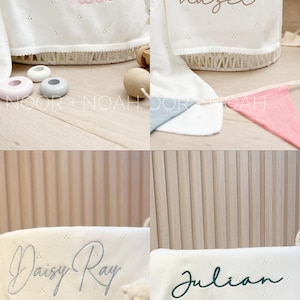 May include: White baby blankets with embroidered names: "Madeline Rose", "Hazel", "Daisy Ray", and "Julian". Each blanket is displayed in a white wicker basket. The names are in pink, brown, gray, and green script.