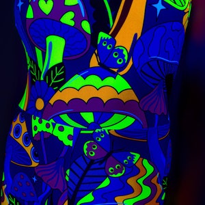 May include: A black background with a psychedelic pattern of mushrooms and butterflies in neon green, orange, purple, and blue colors.