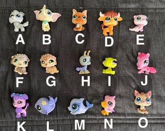 May include: A collection of 15 colorful plastic toy pets, including a grey wolf, a yellow elephant, a brown dog, a brown bull, a pink otter, a brown hedgehog, a brown owl, a grey and blue bug, a green lizard, a pink and purple pig, a purple poodle, a blue whale, a blue dolphin, a pink flamingo, and a brown cat.