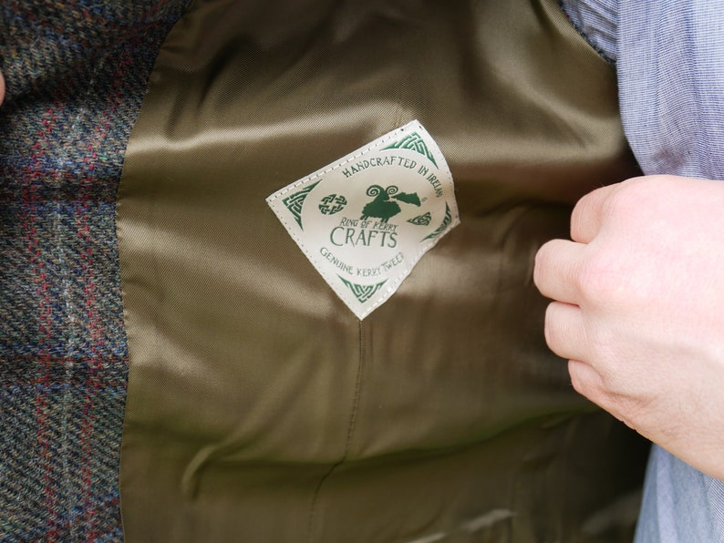 Peut inclure: Une &eacute;tiquette verte et blanche avec le texte "Ring of Kerry Crafts" et "Handcrafted in Ireland" &agrave; l'int&eacute;rieur d'un losange. L'&eacute;tiquette est cousue &agrave; l'int&eacute;rieur d'une veste en tweed marron.