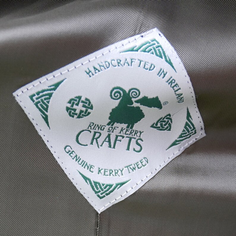 May include: White label with green text and a green sheep illustration. The label reads "Handcrafted in Ireland", "Ring of Kerry Crafts", and "Genuine Kerry Tweed".