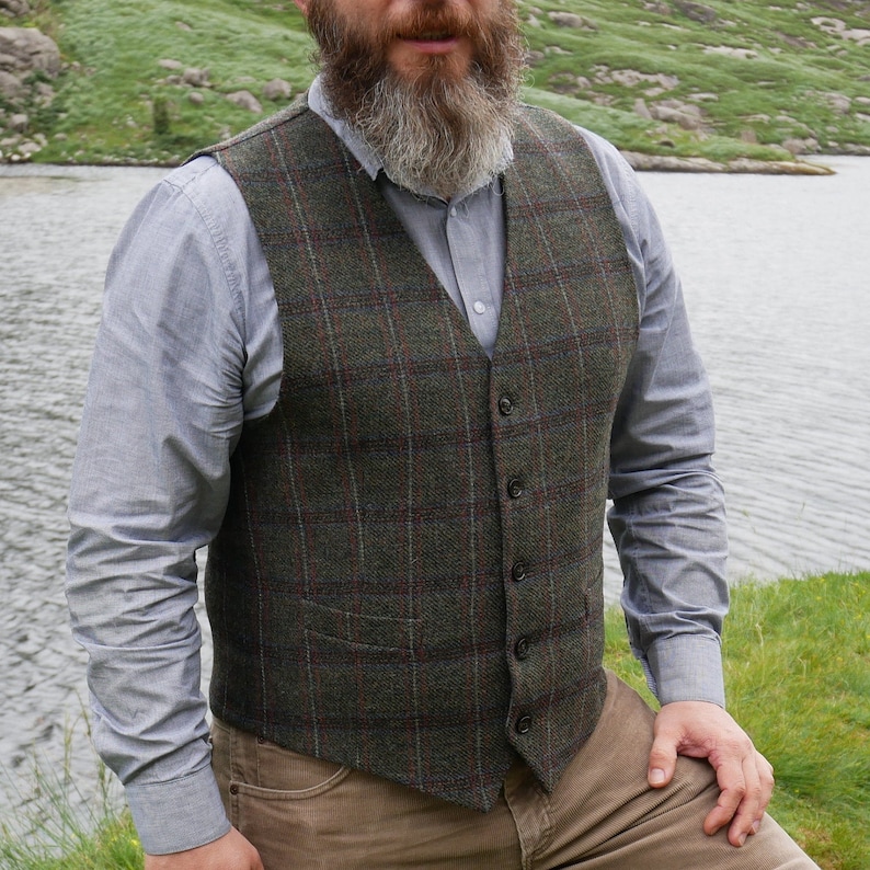 Peut inclure: Un gilet en tweed &agrave; carreaux vert, marron et rouge avec une fermeture &agrave; boutons. Le gilet est de style classique.