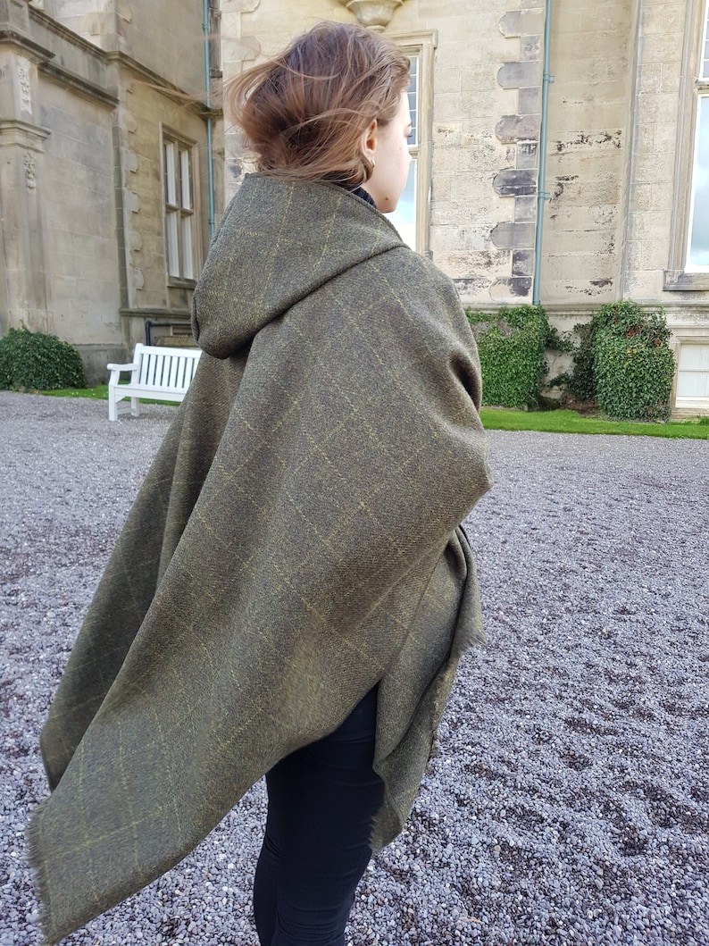 May include: A green hooded cape with a plaid pattern. The cape is made of a soft, warm fabric and is perfect for keeping you warm on chilly days.