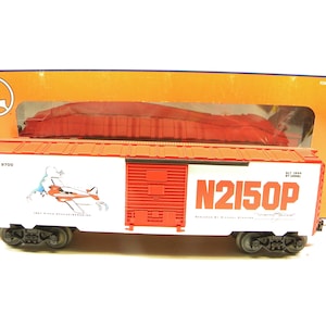 Peut inclure: Un wagon de train modèle en bois rouge et blanc avec le texte "N2150P" et "1939 Piper Aircraft Corp." imprimé sur le côté. Le wagon est dans une boîte avec un fond rouge et orange.