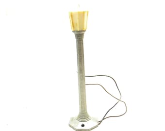 May include: A vintage metal lamp post with a white plastic lampshade. The lamp post has a decorative base and is wired with a cord.