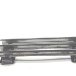 May include: A section of model train track, featuring three parallel rails held together by black plastic supports. The metal rails have a silver finish and are slightly weathered. The track is designed for model train enthusiasts.