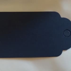 May include: A dark blue gift tag with a scalloped edge and a hole for string.