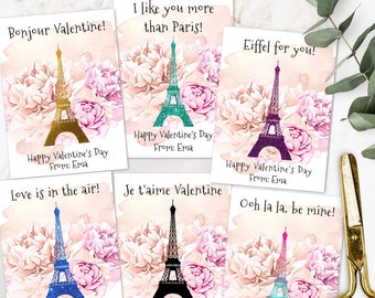 May include: Six printable Valentine's Day cards featuring a watercolor illustration of the Eiffel Tower with pink flowers. Each card has a different color Eiffel Tower and a different romantic message. The messages include "Bonjour Valentine!" "I like you more than Paris!" "Eiffel for you!" "Love is in the air!" "Je t'aime Valentine" and "Ooh la la, be mine!"