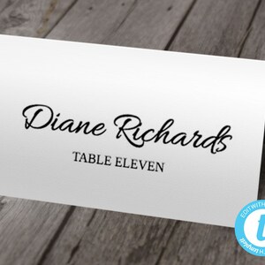 May include: White place card with black text. The text reads "Diane Richards" and "Table Eleven".
