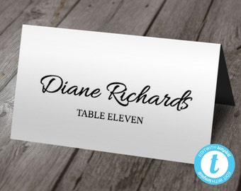 May include: White place card with black text. The text reads "Diane Richards" and "Table Eleven".