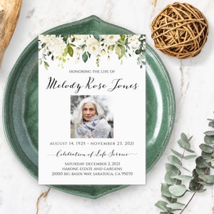 Può includere: Un biglietto bianco con un bordo floreale e una foto in bianco e nero di una donna. Il testo sul biglietto recita "Honoring the Life of Melody Rose Jones", "August 14, 1925 - November 23, 2021", "Celebration of Life Service", "Saturday December 2, 2021", "Hakone Estate and Gardens", e "21000 Big Basin Way, Saratoga, CA 95070".