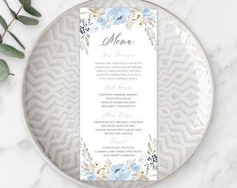 Puede incluir: Una tarjeta de menú floral azul y blanca con la palabra "Menú" en letra cursiva. El menú incluye aperitivos, un primer plato, un plato principal y un postre.