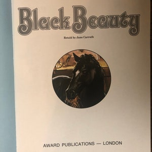 May include: A book cover with the title "Black Beauty" by Anna Sewell, retold by Jane Carrruth. The cover features a black horse with a brown mane and tail, eating hay in a stable.