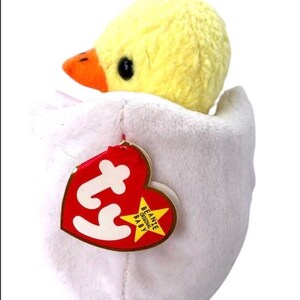 May include: A yellow chick plush toy inside a white egg-shaped plush toy. The toy has a red Ty tag with the words "Beanie Original Baby" on it.