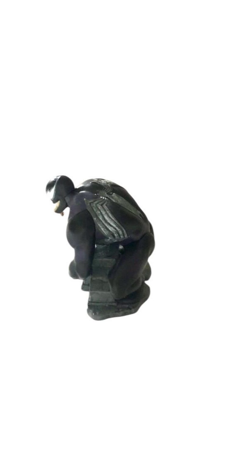May include: Black and gray Venom action figure in a crouching pose. The figure is made of plastic and has a detailed sculpt.