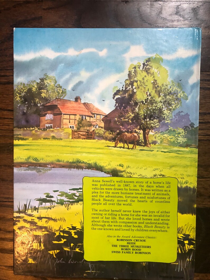 May include: A vintage book cover with a watercolor illustration of a house and a horse in a green field. The text on the cover reads "Anna Sewell's well-known story of a horse's life was published in 1887, in the days when all vehicles were drawn by horses. It was written as a plea for the more humane treatment of animals, and the adventures, fortunes and misfortunes of Black Beauty moved the hearts of countless people all over the world."