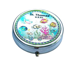 Könnte beinhalten: Eine runde Metallpillendose mit einem bunten Bild von Fischen und Korallen auf dem Deckel. Der Deckel trägt die Aufschrift "St. Thomas U.S.V.I."
