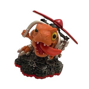 May include: Orange and silver action figure of a cartoonish dragon-like creature with a red propeller on its head and a long red tongue sticking out. The figure is mounted on a black and red base.