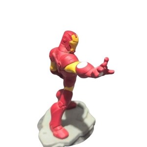Puede incluir: Figurilla de Iron Man roja y amarilla de pie sobre una base de roca gris. La figura est&aacute; en una pose de superh&eacute;roe con un brazo extendido.