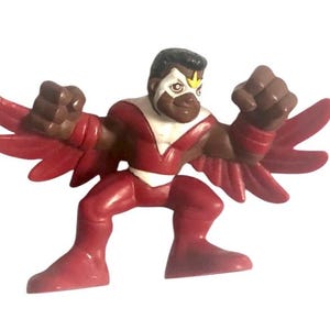 May include: A red and white action figure of a superhero with wings. The figure is in a fighting pose with its fists clenched.