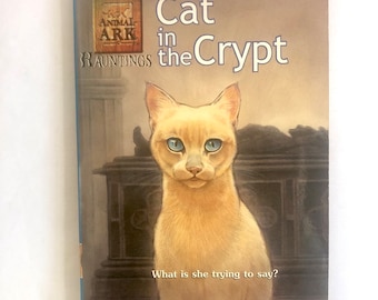 Könnte beinhalten: Ein Buchcover mit einer gelben Katze mit blauen Augen, die in einer Krypta sitzt. Der Buchtitel lautet "Cat in the Crypt" und ist Teil der Reihe "Animal Ark Hauntings". Der Autor ist Ben M. Baglio.