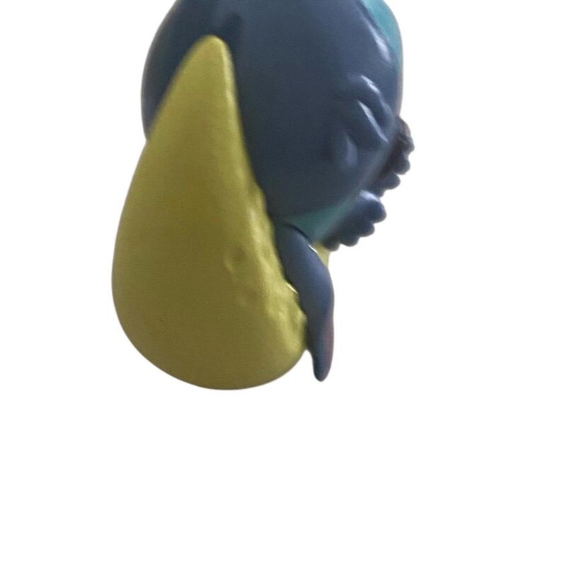 K&ouml;nnte beinhalten: Nahaufnahme einer blau-gelben Figur einer Zeichentrickfigur. Die Figur hat ein gro&szlig;es gelbes Ohr und einen blauen K&ouml;rper. Das Gesicht der Figur ist sichtbar, mit kleinen Details.