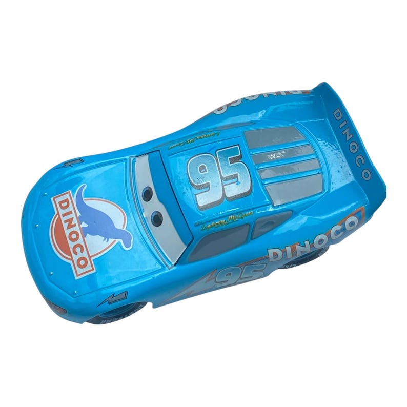 May include: A light blue toy race car with the number 95 on the side. The car has the Dinoco logo on the side and the back. The car is a toy from the movie Cars.