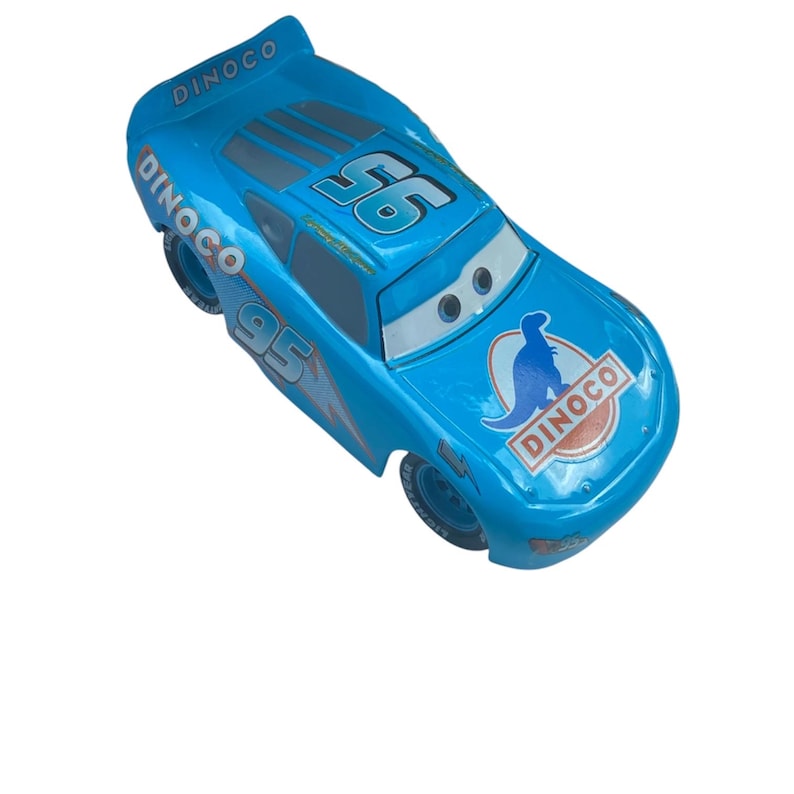 May include: A light blue toy race car with the number "95" and the word "Dinoco" printed on it. The car has a lightning bolt design and the number "56" on the roof. The car has a cartoon dinosaur logo on the hood.