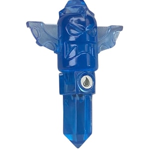 Op de afbeelding: Een doorschijnend blauw beeldje met een totemachtig ontwerp. Het heeft vleugelachtige structuren aan de zijkanten en een druppelsymbool. Het beeldje heeft een kristalachtig uiterlijk en is ontworpen met ingewikkelde details.
