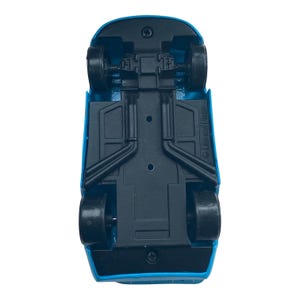 May include: Underside view of a blue toy car with black wheels. The car's chassis is black, and the Disney/Pixar logo is visible. The toy car is a miniature replica.