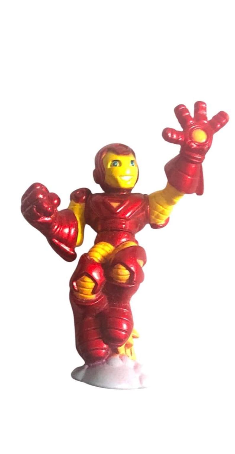 以下が含まれることがあります： 金属製の仕上げが施された赤と黄色のアイアンマンのアクションフィギュア。フィギュアは片腕を上げ、もう片方の腕を肘で曲げてポーズをとっている。フィギュアは白い台座の上に立っている。