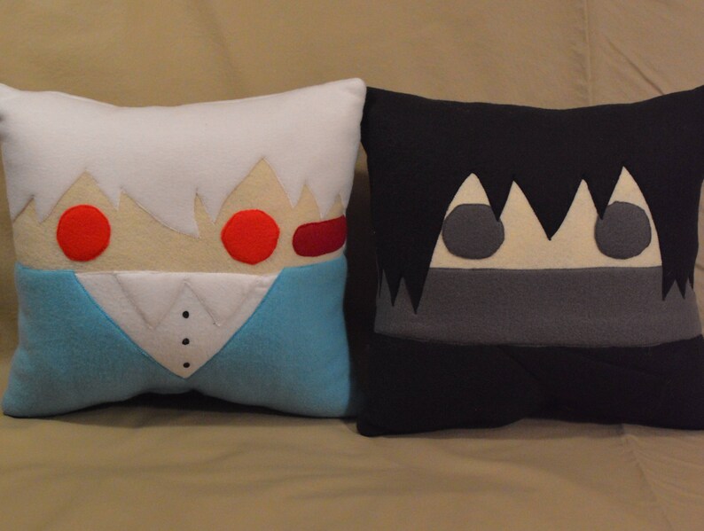 May include: Two plush pillows, one white with red eyes and a blue shirt, the other black with grey eyes and a grey mouth.