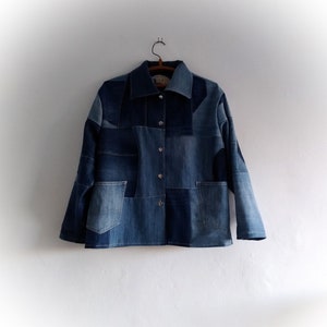 May include: A blue denim jacket made from patchwork fabric. The jacket has a button-up front and a collar.