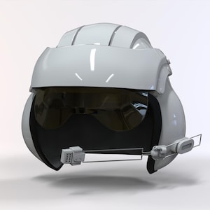 Op de afbeelding: Een witte helm met een donker vizier en een communicatie-apparaat. De helm heeft een gladde, glanzende afwerking en een gestroomlijnd ontwerp, wat wijst op een focus op aerodynamica en bescherming.