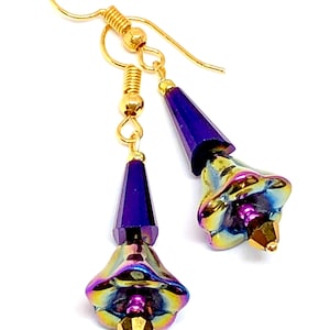 May include: A pair of dangle earrings with iridescent purple and gold flower-shaped beads and gold hooks.