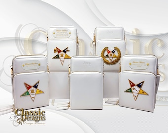 May include: Six white leather phone pouches with gold zippers and straps. Each pouch features a different Masonic emblem, including a five-pointed star, a key and compass, and a wreath. The pouches are displayed on a white surface.