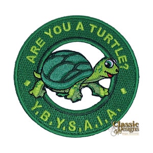 Pode incluir: Etiqueta bordada verde com uma tartaruga de desenho animado e o texto "Are you a turtle? Y.B.Y.S.A.I.A."