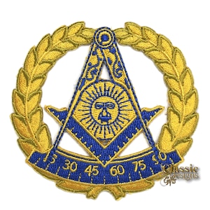Peut inclure: Un écusson maçonnique brodé en or et bleu avec un compas et une équerre, un soleil avec un visage et une couronne de feuilles. Les chiffres 15, 30, 45, 60, 75 et 90 sont visibles sur le rapporteur.
