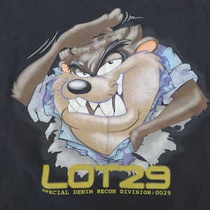May include: A black t-shirt featuring a graphic of the Tasmanian Devil character emerging from a torn blue camouflage shirt. Below the character, the text reads LOT29 in large yellow letters, followed by SPECIAL DENIM RECON DIVISION:0029.