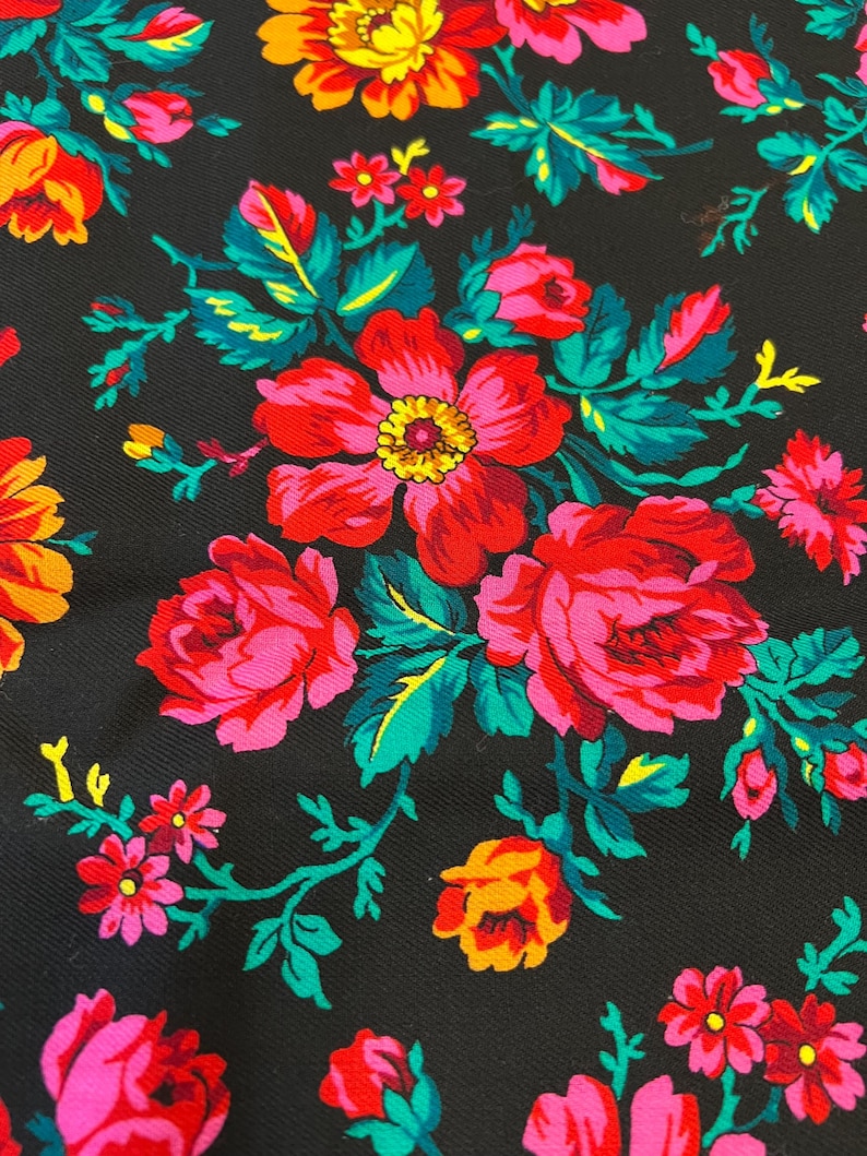 May include: Black fabric with a floral pattern featuring pink, red, orange, and yellow flowers with green leaves.