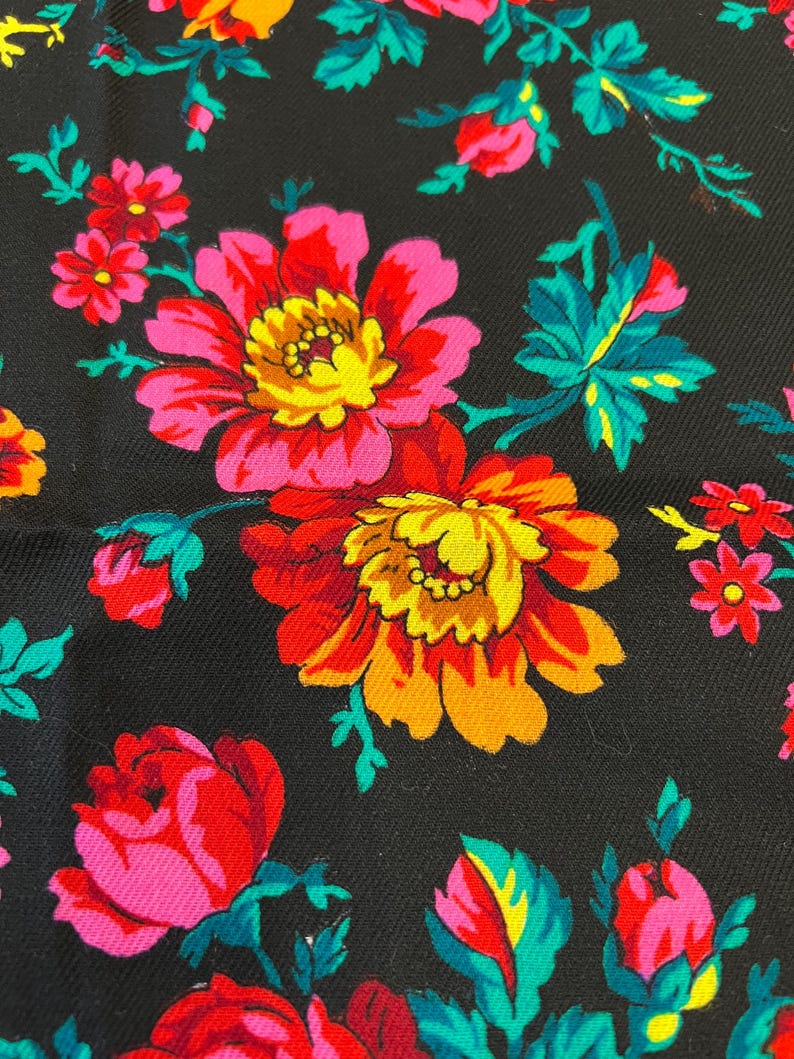 May include: Black fabric with a floral pattern featuring pink, red, yellow, and green flowers. The flowers are stylized and have a vintage look.