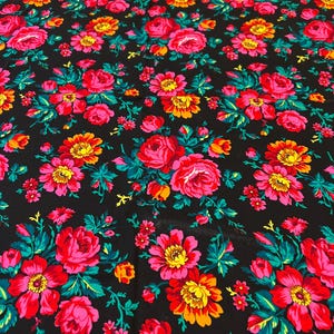 May include: Black fabric with a repeating floral pattern. The flowers are pink, red, yellow, and orange with green leaves.