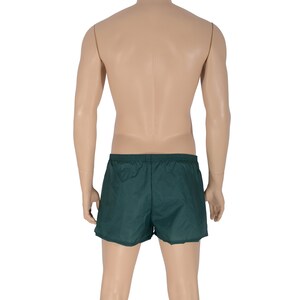 May include: A pair of dark green athletic shorts with an elastic waistband.