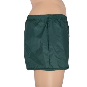 May include: Dark green nylon athletic shorts with an elastic waistband.